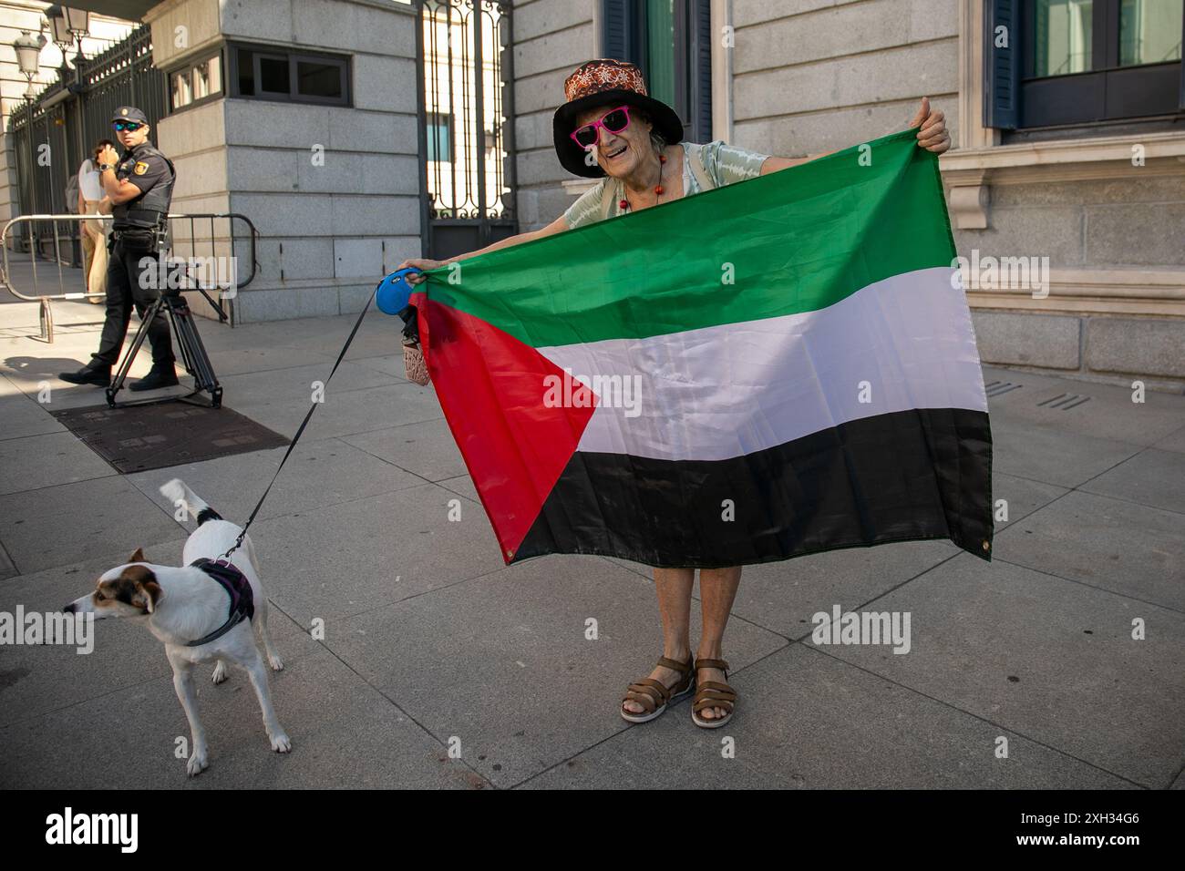 Eine Frau trägt heute Morgen eine palästinensische Flagge, begleitet von ihrem Hund vor dem Abgeordnetenkongress. Vertreter von mehr als 500 Organisationen, Gewerkschaften und Nachbarschaftsverbänden der Kampagne "Ende des Waffenhandels mit Israel" haben im Abgeordnetenkongress einen Vorschlag zur Aufnahme des Militärembargos in die spanische Gesetzgebung eingereicht. Mit der Einführung dieser gesetzlichen Zahl wäre es möglich, den Kauf und Verkauf von Waffen und Verteidigungsmaterial an Israel zu unterbrechen. (Foto: David Canales/SOPA Images/SIPA USA) Stockfoto Eine Frau trägt heute Morgen eine palästinensische Flagge, begleitet von ihrem Hund vor dem Abgeordnetenkongress. Vertreter von mehr als 500 Organisationen, Gewerkschaften und Nachbarschaftsverbänden der Kampagne "Ende des Waffenhandels mit Israel" haben im Abgeordnetenkongress einen Vorschlag zur Aufnahme des Militärembargos in die spanische Gesetzgebung eingereicht. Mit der Einführung dieser gesetzlichen Zahl wäre es möglich, den Kauf und Verkauf von Waffen und Verteidigungsmaterial an Israel zu unterbrechen. (Foto: David Canales/SOPA Images/SIPA USA) Stockfoto