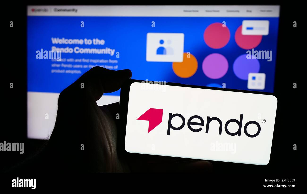 Person mit Smartphone und Logo des US-Softwareunternehmens Pendo.io Inc. Vor der Website. Schwerpunkt auf dem Display des Telefons. Stockfoto