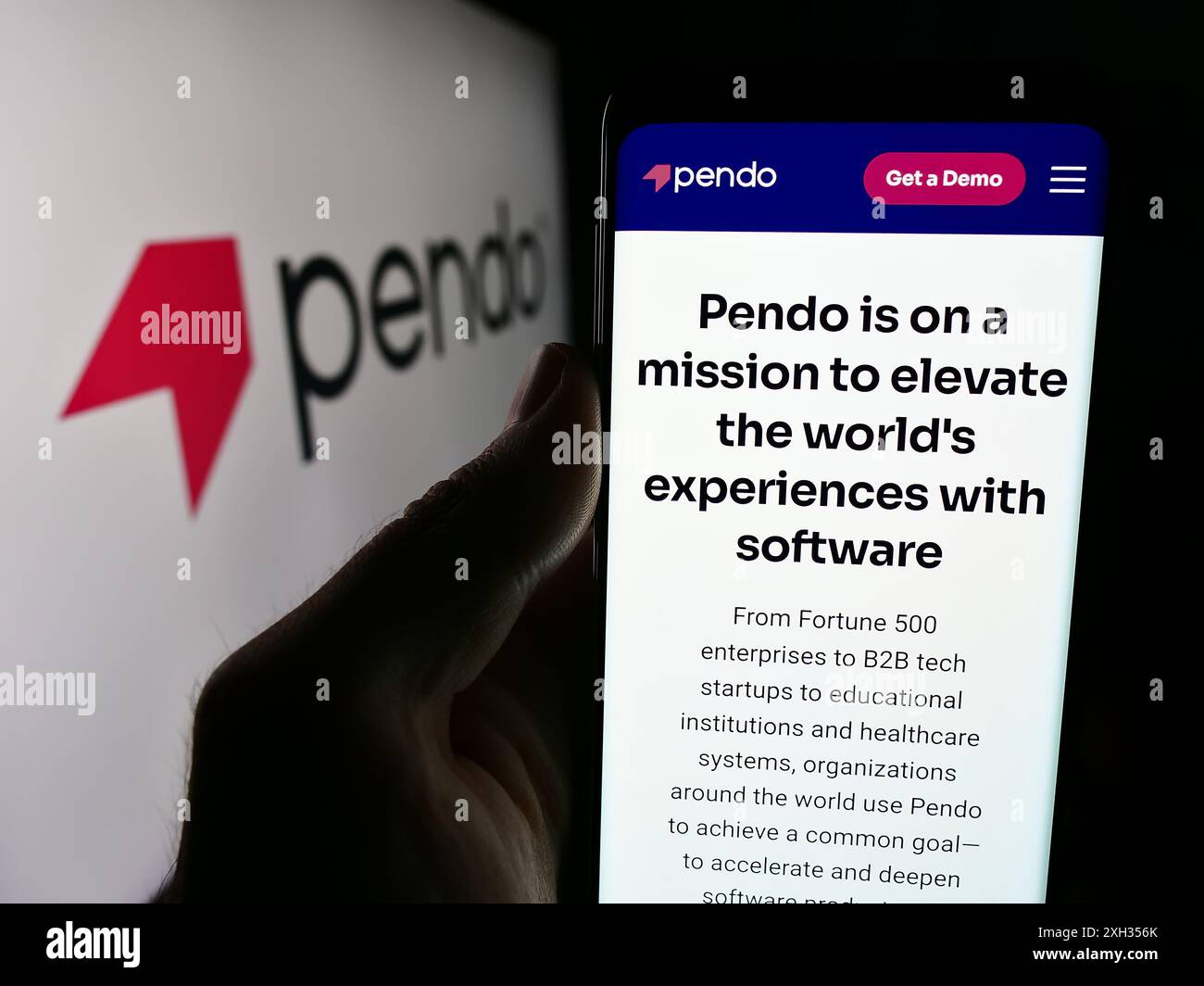 Person, die ein Mobiltelefon hält, mit der Webseite des US-Softwareunternehmens Pendo.io Inc. Vor dem Firmenlogo. Konzentrieren Sie sich auf die Mitte des Telefondisplays. Stockfoto