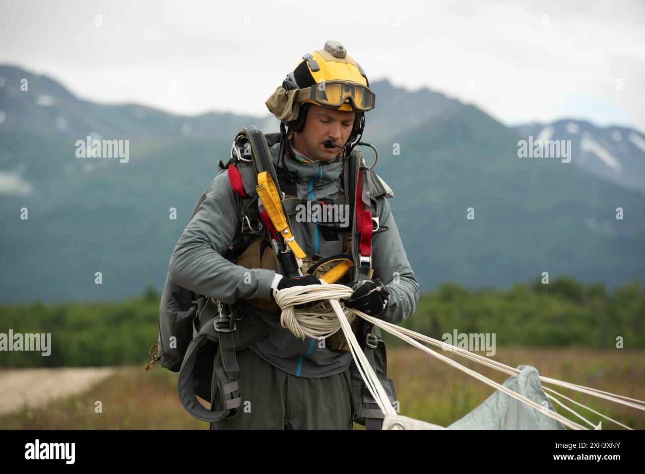 Ein Pararescueman der Alaska Air National Guard von der 212th Rescue Squadron packt seine Ausrüstung, nachdem er am 9. Juli 2024 Luftlandeoperationen in der Malemute Drop Zone, Joint Base Elmendorf-Richardson, Alaska, durchgeführt hat. Die Guardsmen der 212. RQS und die 3. ASOS TACP Special Warfare Airmen führten gemeinsame luftgestützte Schulungen durch, um die Fähigkeiten der PJ bei der Durchführung von Personalrückgewinnung im gesamten Spektrum zu erhalten, wobei sowohl konventionelle als auch unkonventionelle Rettungseinsätze einbezogen wurden, und die TACP, tödliche und nichttödliche gemeinsame Feuerkraft zu lenken, wann immer nötig. (Foto der U.S. Air Force von Nicholas Holland) Stockfoto