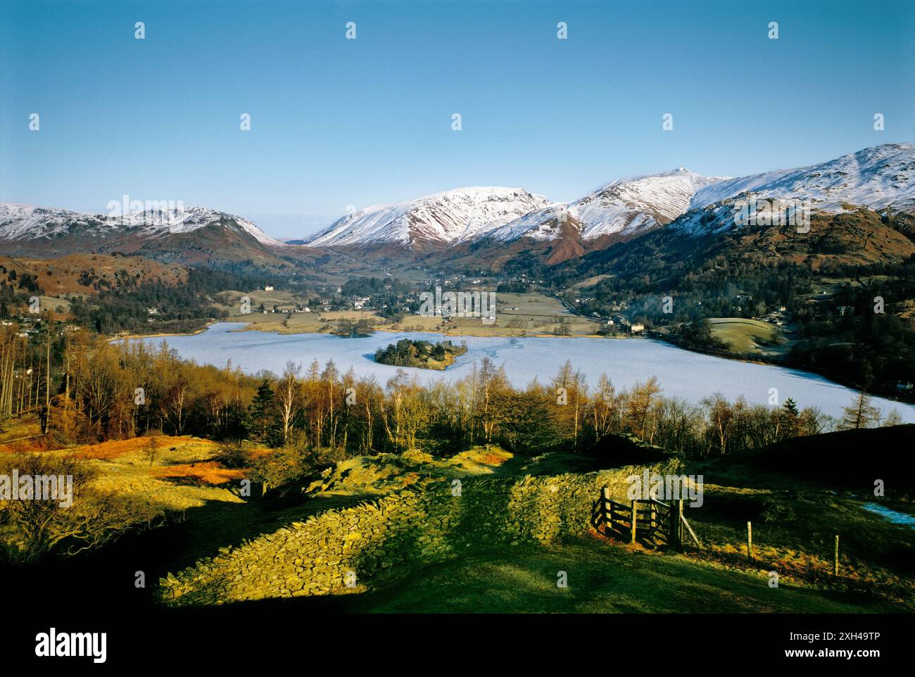 Norden über Grasmere Tal Dorf im Nationalpark Lake District, Cumbria, England. Zugefrorenen See und Schnee in den Bergen. Winter. Stockfoto