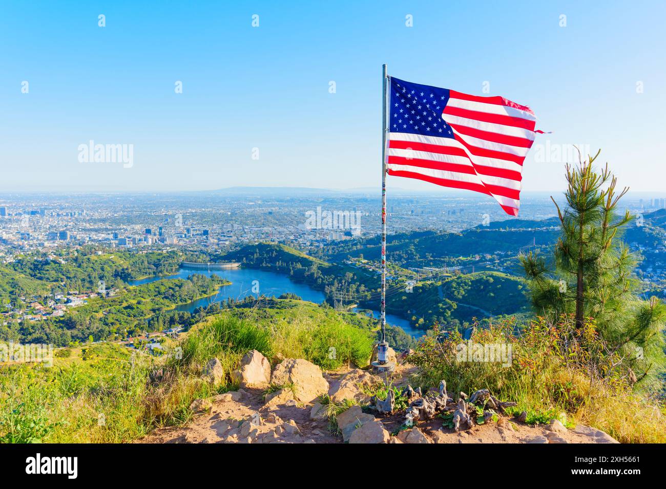 Los Angeles, Kalifornien - 16. April 2024: Amerikanische Flagge flattert im Wind über dem Panoramablick auf die Stadt Los Angeles Stockfoto