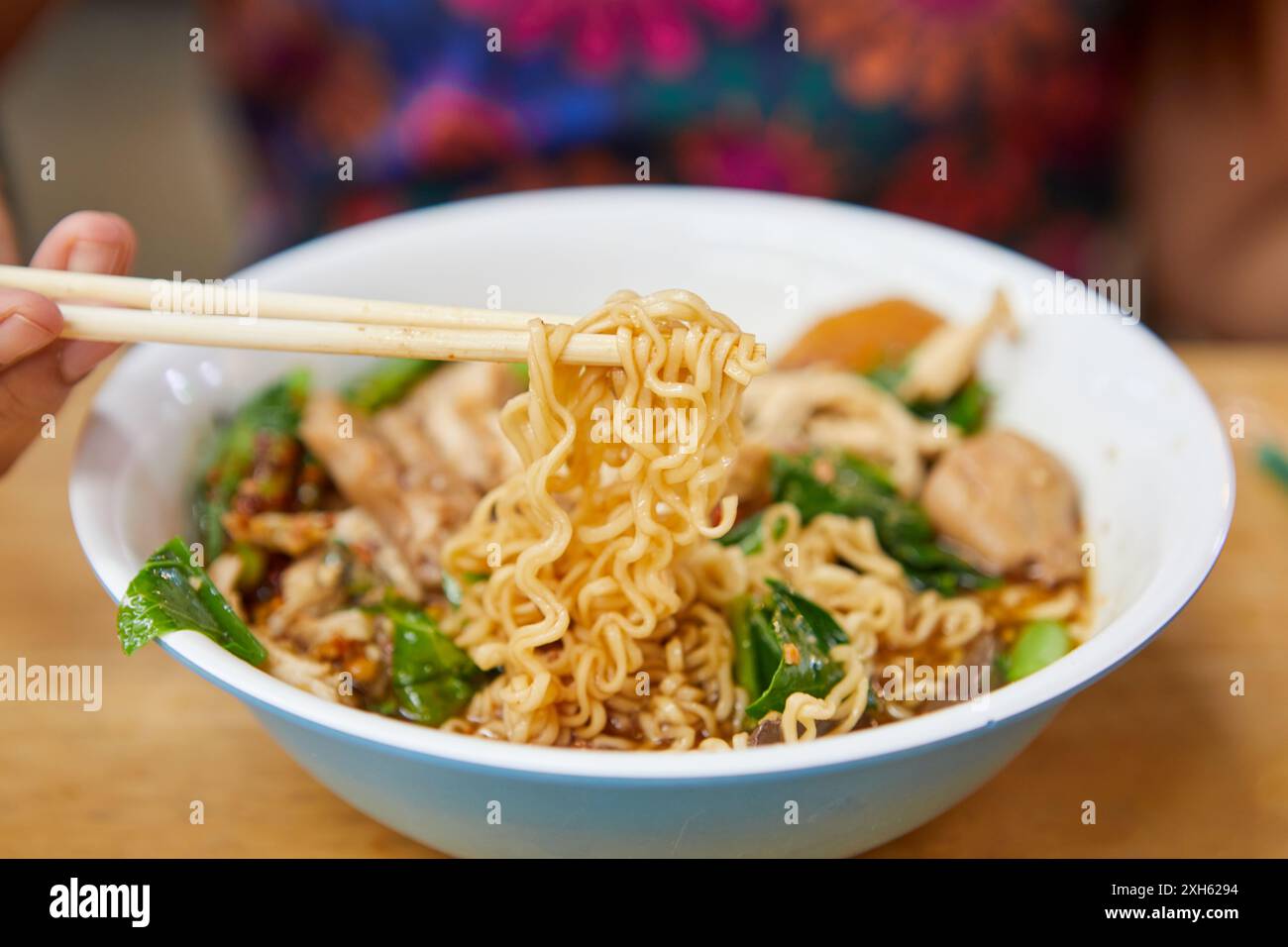 Midsection of woman eating instant noodles in a bowl Stockfoto