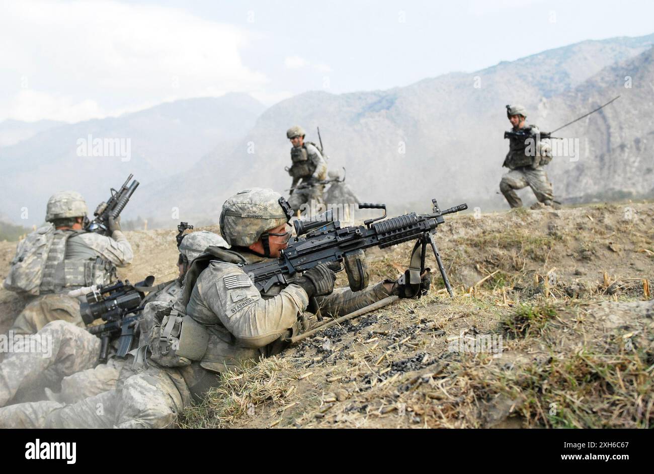 Soldaten der US-Armee von Kompanie C, 2. Bataillon, 12. Infanterieregiment, beobachten die umliegenden Hügel nach Aufständischen, während Fellow Co. C-Soldaten rennen zu ihrer Position, indem sie schwerem Scharfschützenfeuer ausweichen, während eines dreistündigen Waffenschlages mit Aufständischen in der Provinz Kunar, dem afghanischen Waterpur-Tal, am 3. November. Die Soldaten der 4. Infanteriedivision kämpfen seit ihrer Ankunft in Afghanistan im Juni letzten Jahres gegen aufständische Kräfte im Waterpur-Tal. 5. Mobile Abteilung für öffentliche Angelegenheiten Foto von Sgt. Matthew Moeller Datum: 11.03.2009 Ort: Provinz Kunar. Stockfoto