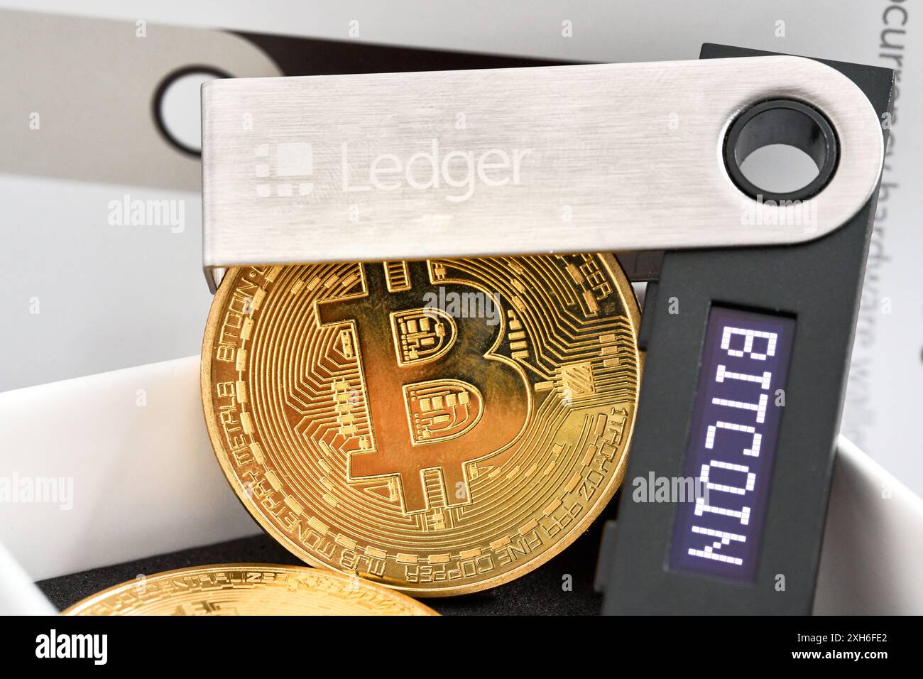 Augsburg, Bayern, Deutschland - 30. Mai 2024: Bitcoin Coins neben einem Ledger Nano S, einer beliebten Hardware-Geldbörse zur sicheren Speicherung von Kryptowährungen. PHOTOMONTAGE *** Bitcoin-Münzen neben einem Ledger Nano S, einer beliebten Hardware-Wallet für die sichere Aufbewahrung von Kryptowährungen. FOTOMONTAGE Stockfoto