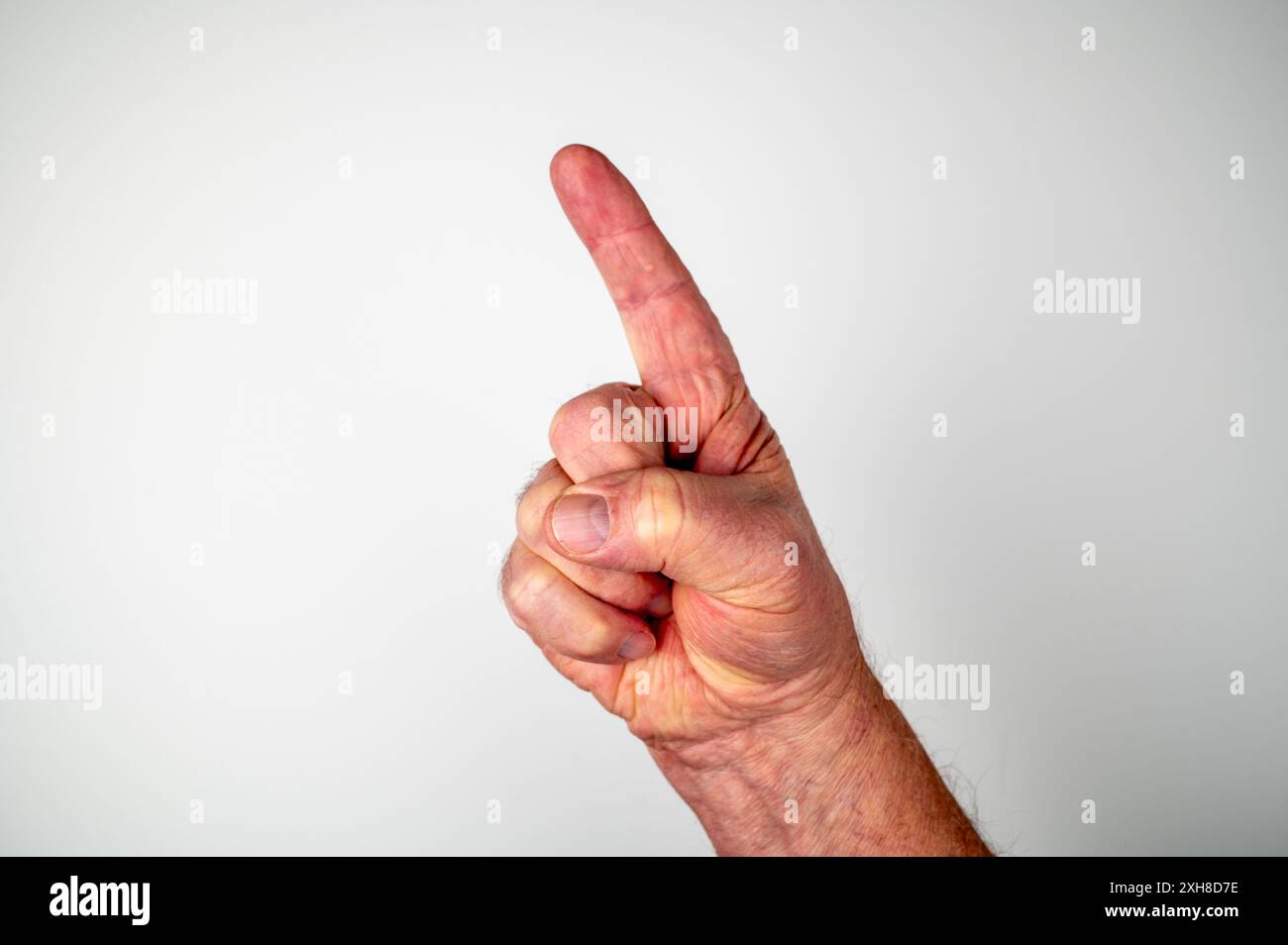 Kaukasische männliche Hand mit Zeigefinger, der auf weißem Hintergrund auf Nummer eins zeigt oder anzeigt Stockfoto