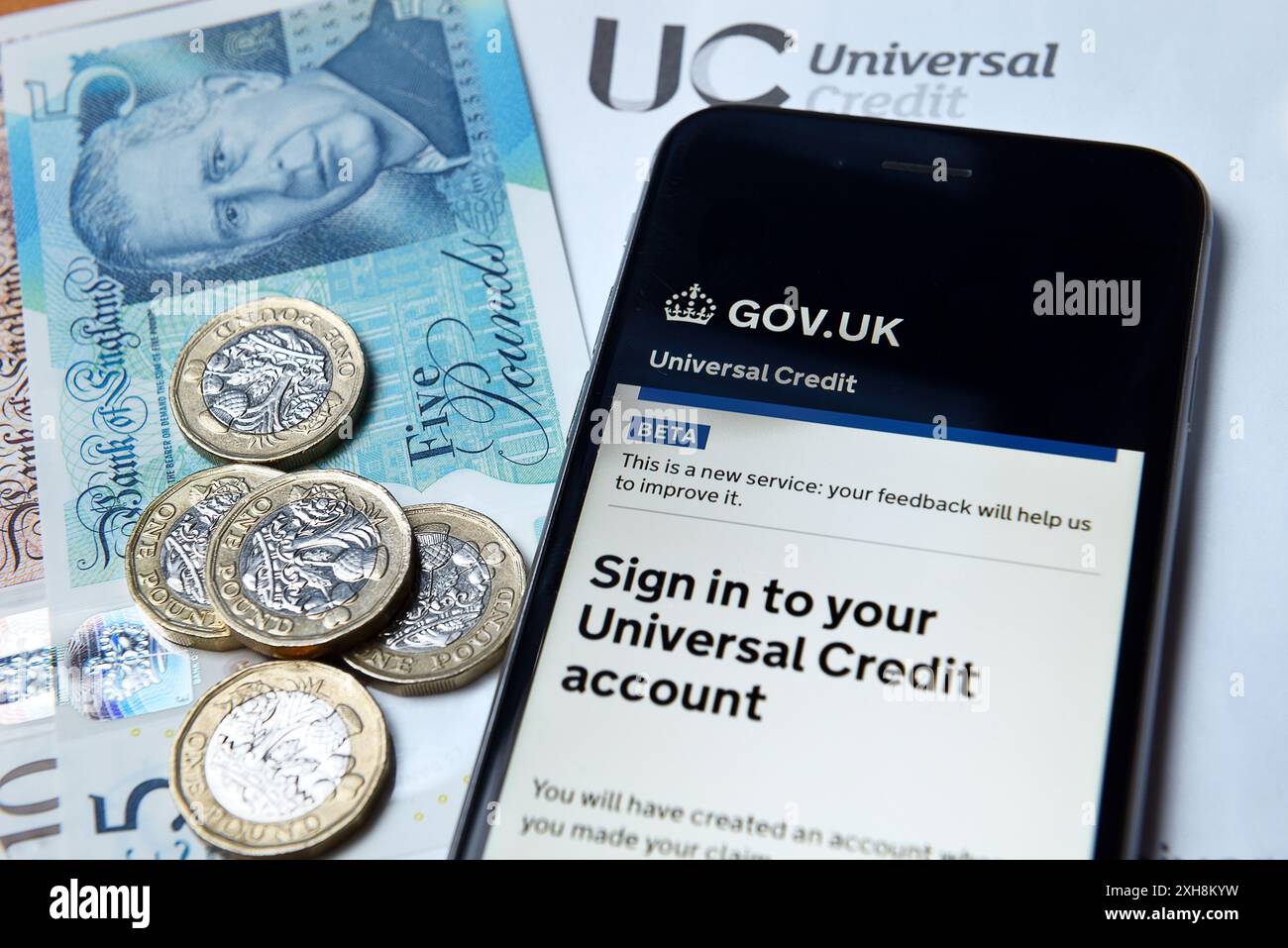 Flache Lage von Universal Credit Sign in und König Charles III. Banknoten Stockfoto