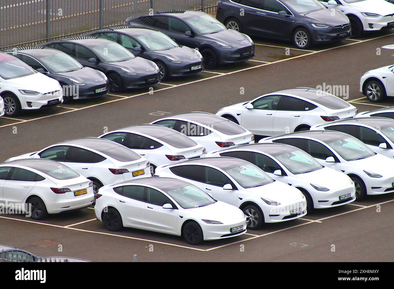 Blaue und weiße Tesla-Elektroautos, die im April 2024 auf den Vertrieb und die Auslieferung an Tesla-Zentren in Großbritannien durch Fahrzeugtransporter warten Stockfoto Blaue und weiße Tesla-Elektroautos, die im April 2024 auf den Vertrieb und die Auslieferung an Tesla-Zentren in Großbritannien durch Fahrzeugtransporter warten Stockfoto