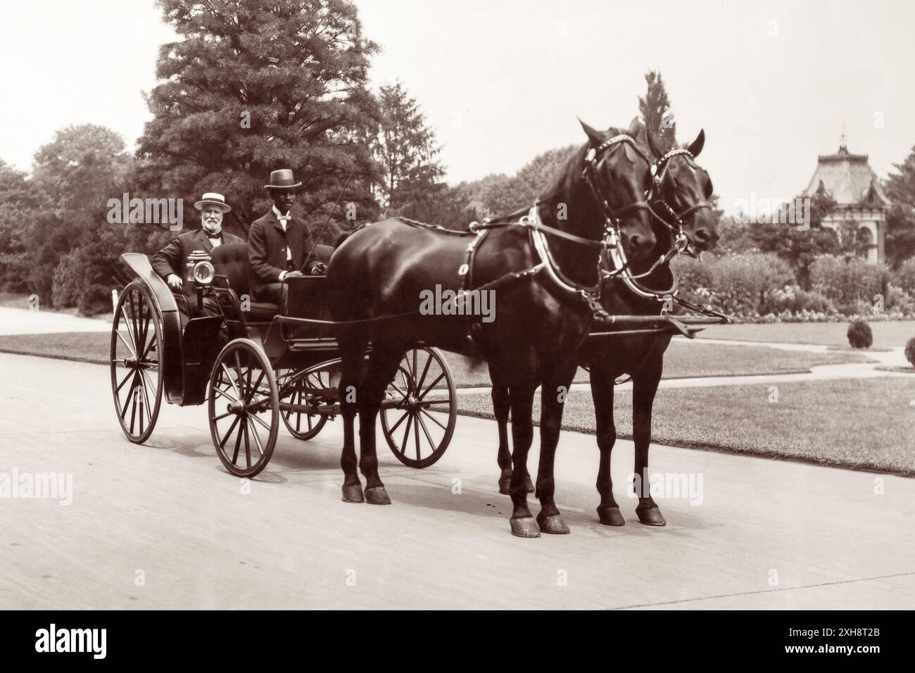 James Wilson (1835–1920), Landwirtschaftsminister von 1897 bis 1913, saß in einer Pferdekutsche mit einem unbekannten afroamerikanischen Fahrer. Wilson war Sekretär während drei Präsidentschaften und hält den Rekord als das am längsten dienende Mitglied des Kabinetts der Vereinigten Staaten. Vor seiner Amtszeit als Secretary war er Professor für Landwirtschaft am Iowa State Agricultural College (heute Iowa State University), wo er George Washington Carver beriet. (USA) Stockfoto