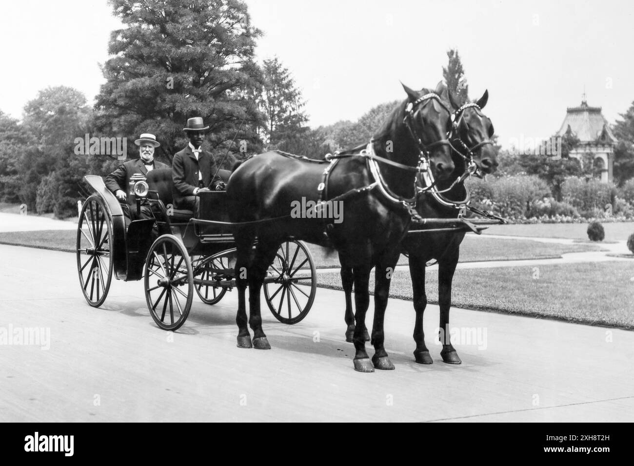 James Wilson (1835–1920), Landwirtschaftsminister von 1897 bis 1913, saß in einer Pferdekutsche mit einem unbekannten afroamerikanischen Fahrer. Wilson war Sekretär während drei Präsidentschaften und hält den Rekord als das am längsten dienende Mitglied des Kabinetts der Vereinigten Staaten. Vor seiner Amtszeit als Secretary war er Professor für Landwirtschaft am Iowa State Agricultural College (heute Iowa State University), wo er George Washington Carver beriet. (USA) Stockfoto