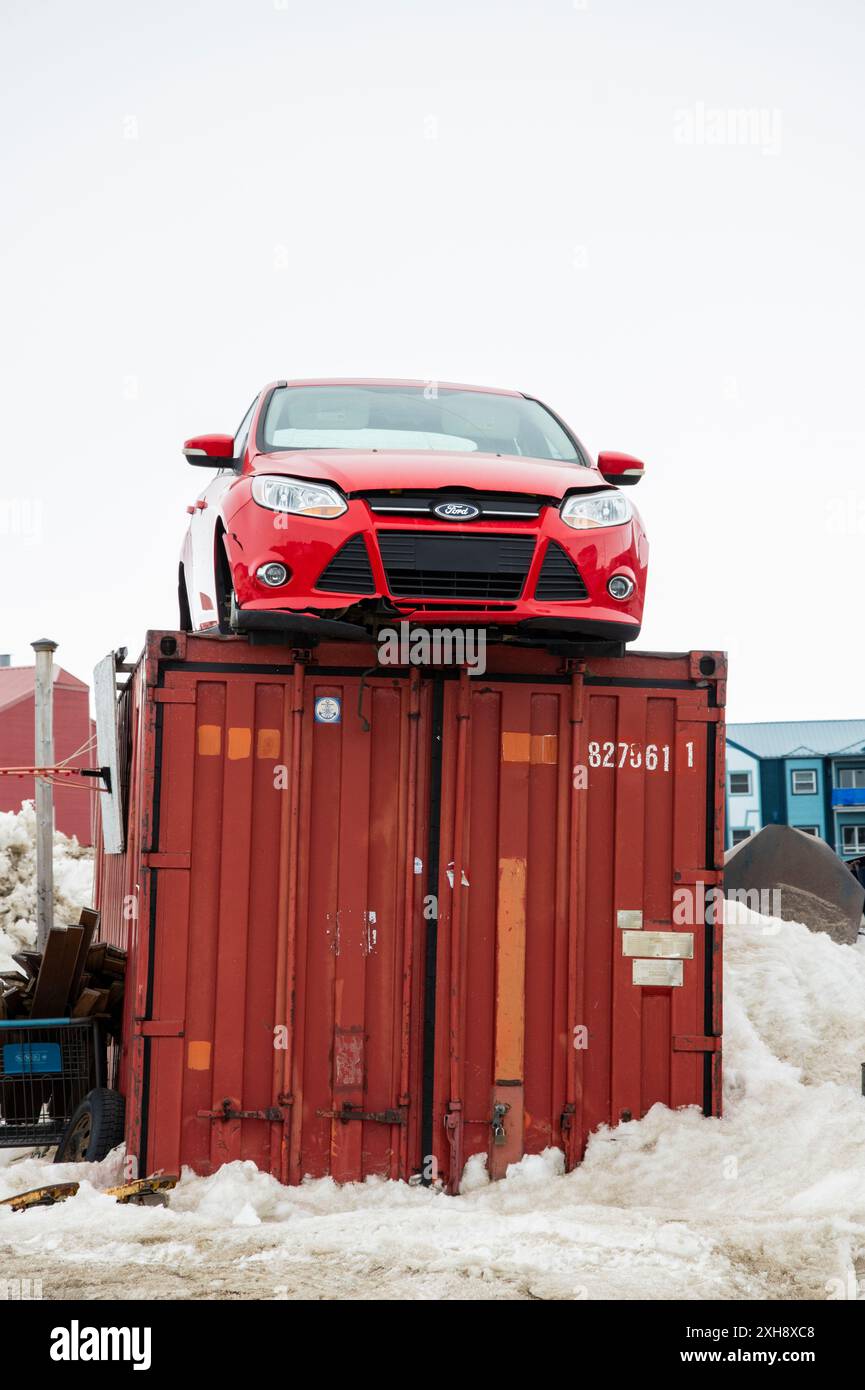 Rotes Auto auf einem Frachtcontainer am Strand der Frobisher Bay in Iqaluit, Nunavut, Kanada Stockfoto