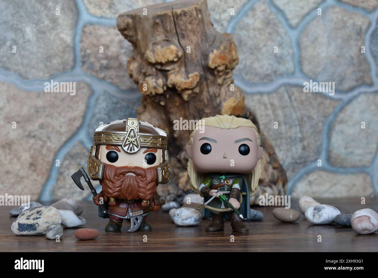 Funko Pop Actionfiguren von Gimli Zwerg und Elf Legolas aus dem Fantasy-Film der Herr der Ringe. Krieger in Rüstung, Baum, Steine. Stockfoto