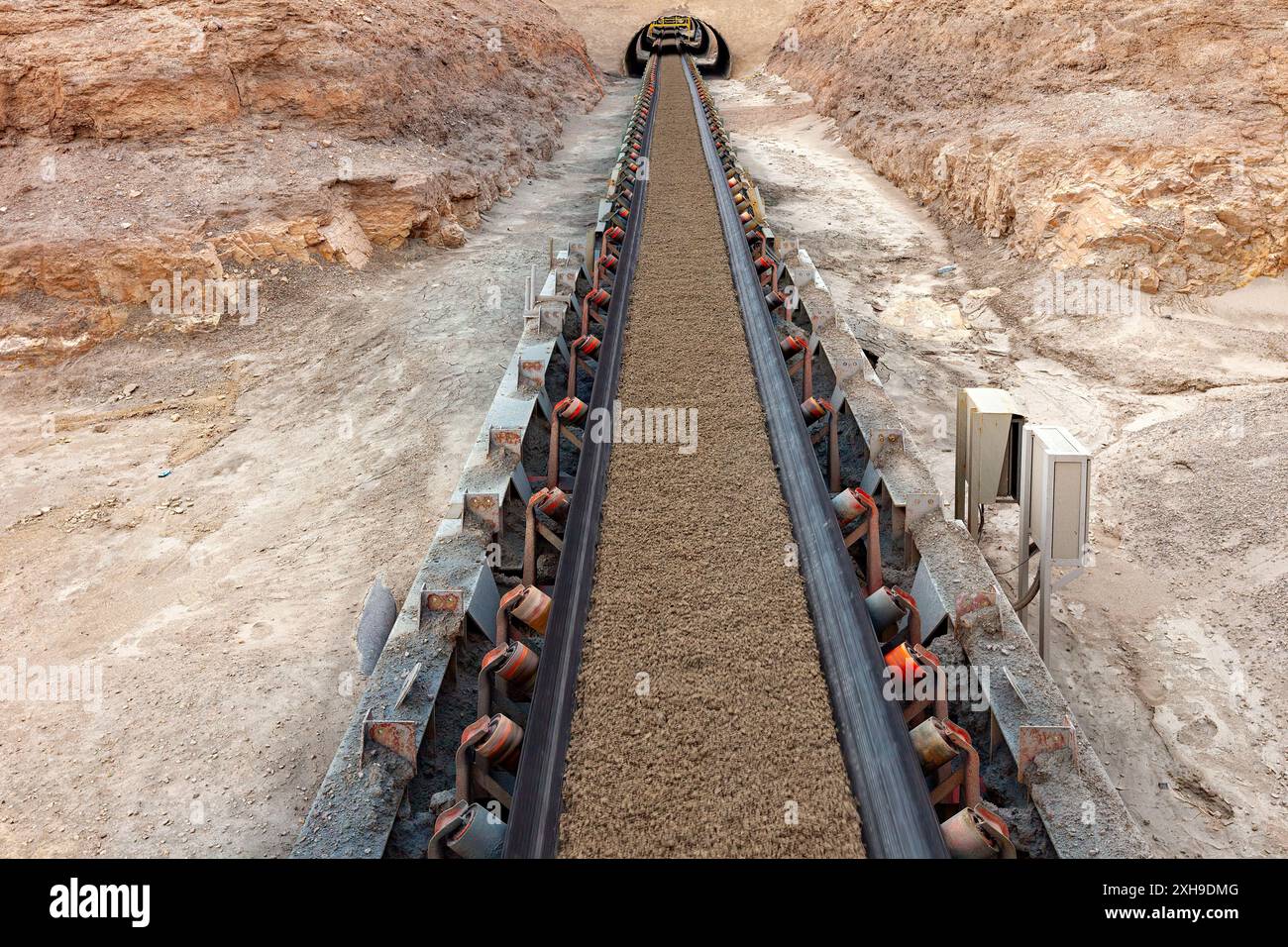 Mineralien, die auf einem langen Förderband in einer Kupfermine transportiert werden. Stockfoto