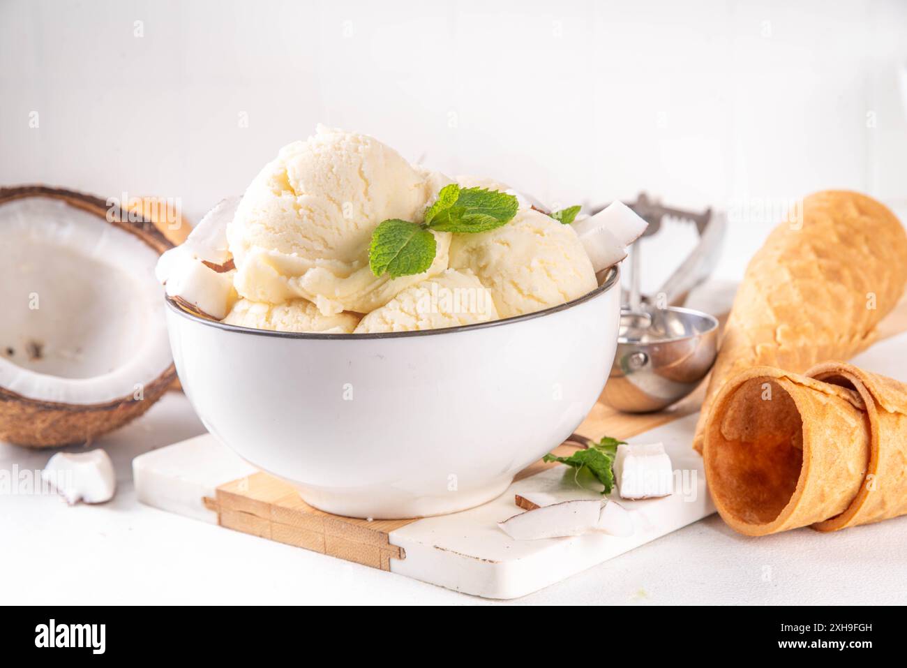 Veganes cremiges Kokos-Sorbet-Eis. Schüssel mit klassischem weißem Kokosgeschmack, vegetarisches Eis aus Kokosmilch, cremig gefrorener Sommer Stockfoto