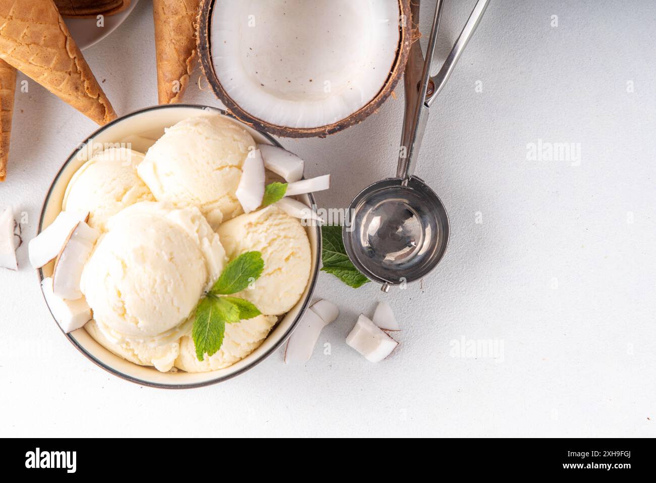 Veganes cremiges Kokos-Sorbet-Eis. Schüssel mit klassischem weißem Kokosgeschmack, vegetarisches Eis aus Kokosmilch, cremig gefrorener Sommer Stockfoto