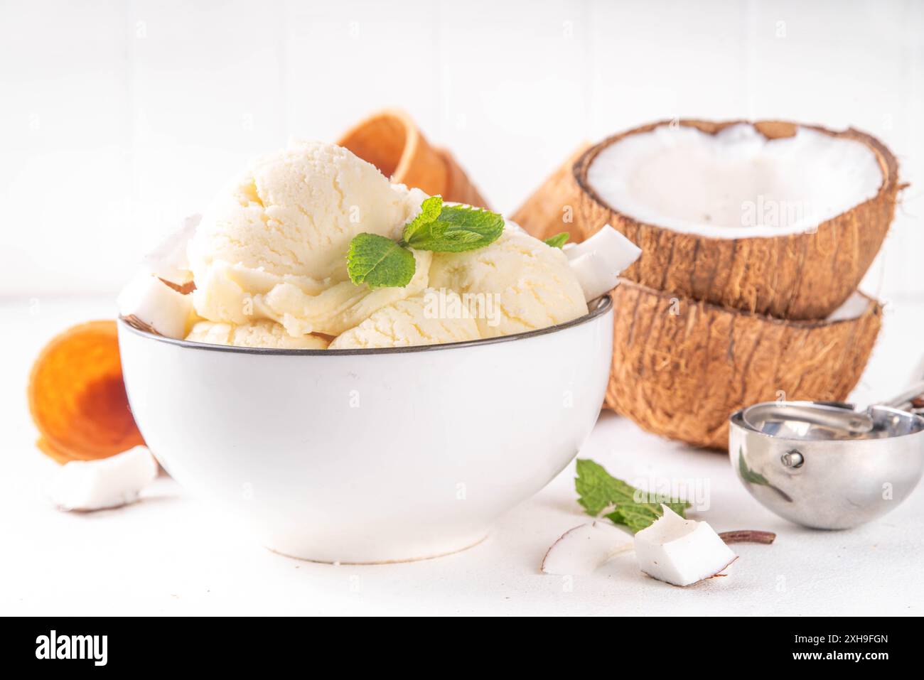 Veganes cremiges Kokos-Sorbet-Eis. Schüssel mit klassischem weißem Kokosgeschmack, vegetarisches Eis aus Kokosmilch, cremig gefrorener Sommer Stockfoto