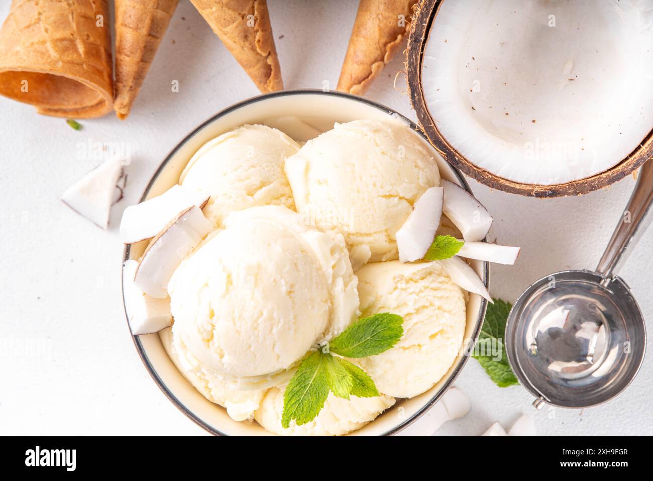 Veganes cremiges Kokos-Sorbet-Eis. Schüssel mit klassischem weißem Kokosgeschmack, vegetarisches Eis aus Kokosmilch, cremig gefrorener Sommer Stockfoto