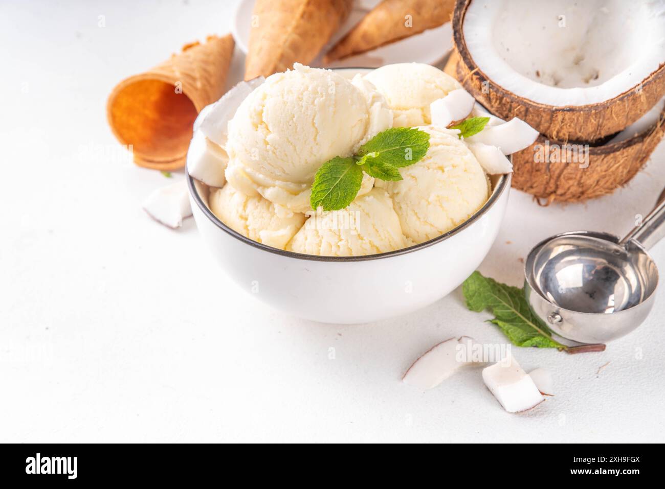 Veganes cremiges Kokos-Sorbet-Eis. Schüssel mit klassischem weißem Kokosgeschmack, vegetarisches Eis aus Kokosmilch, cremig gefrorener Sommer Stockfoto