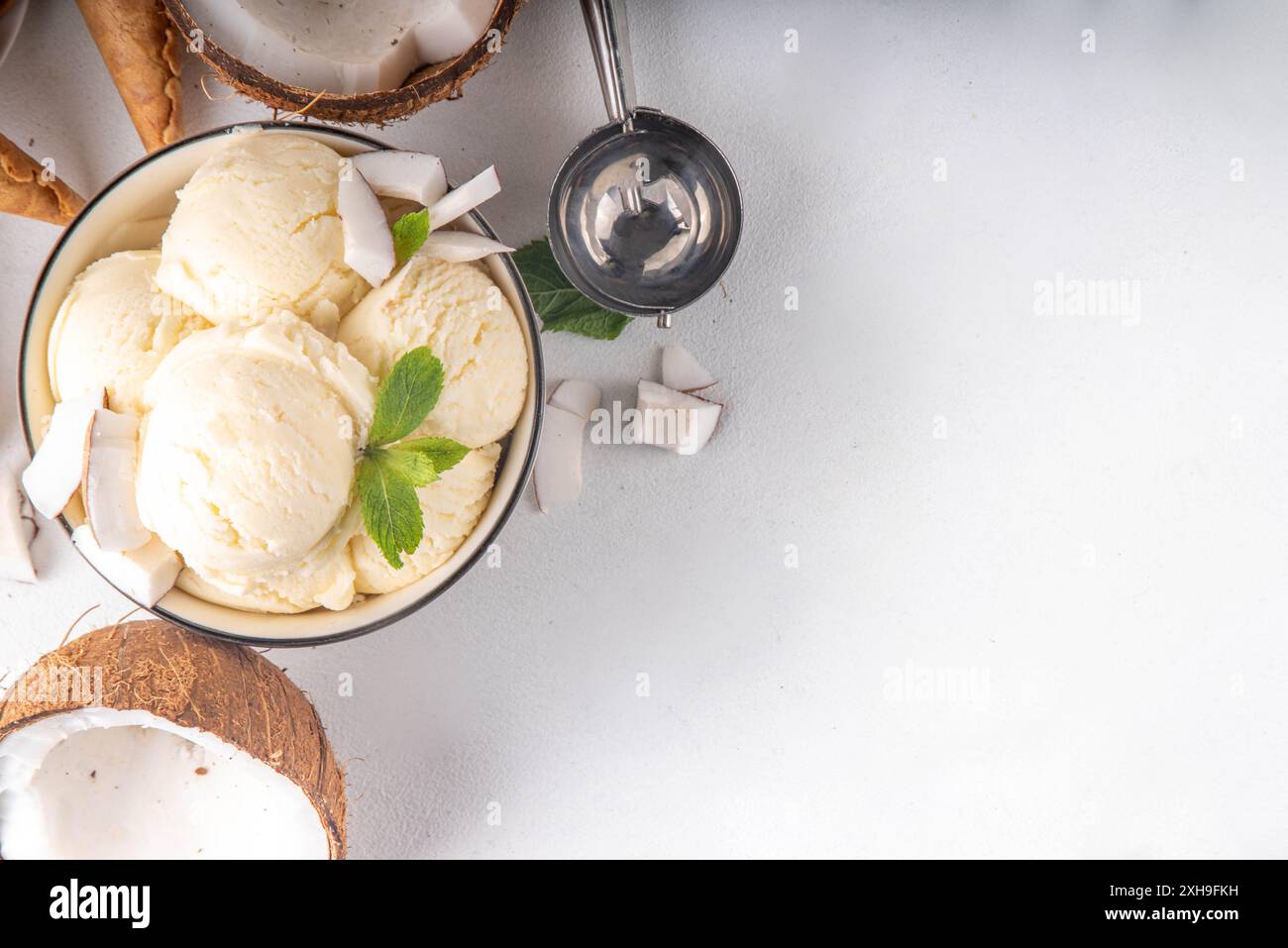 Veganes cremiges Kokos-Sorbet-Eis. Schüssel mit klassischem weißem Kokosgeschmack, vegetarisches Eis aus Kokosmilch, cremig gefrorener Sommer Stockfoto