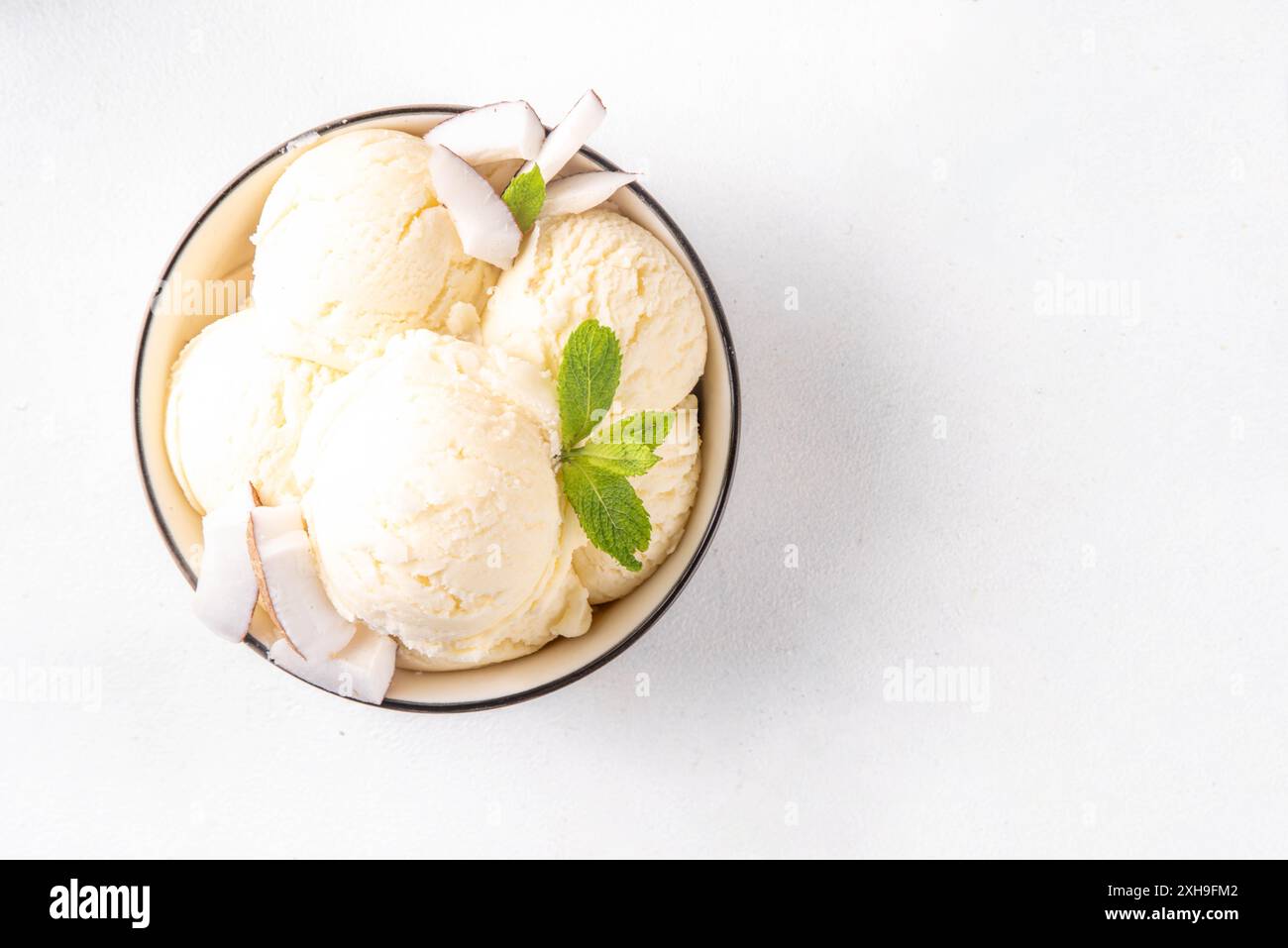 Veganes cremiges Kokos-Sorbet-Eis. Schüssel mit klassischem weißem Kokosgeschmack, vegetarisches Eis aus Kokosmilch, cremig gefrorener Sommer Stockfoto