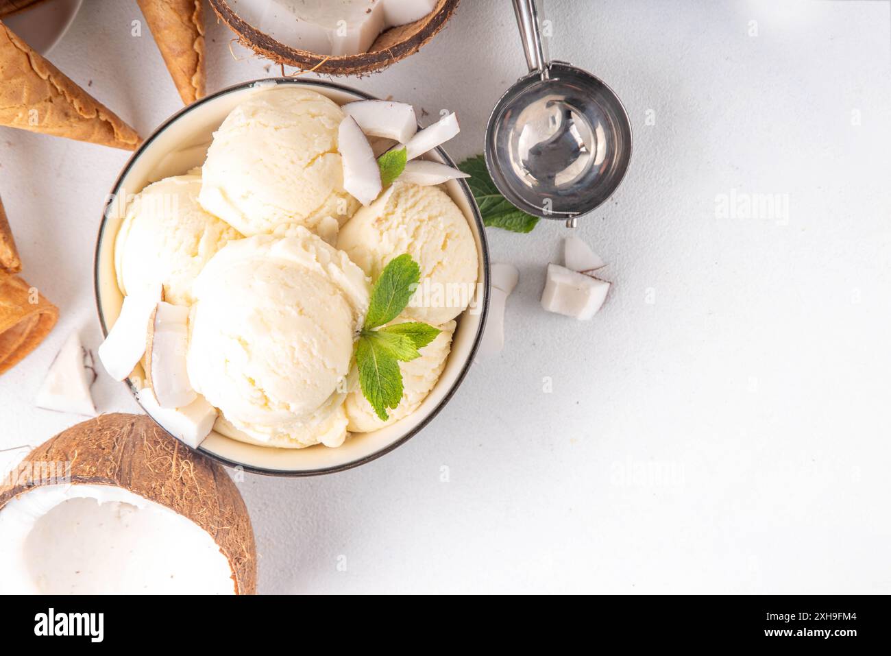 Veganes cremiges Kokos-Sorbet-Eis. Schüssel mit klassischem weißem Kokosgeschmack, vegetarisches Eis aus Kokosmilch, cremig gefrorener Sommer Stockfoto