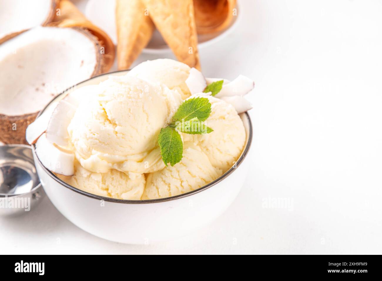 Veganes cremiges Kokos-Sorbet-Eis. Schüssel mit klassischem weißem Kokosgeschmack, vegetarisches Eis aus Kokosmilch, cremig gefrorener Sommer Stockfoto