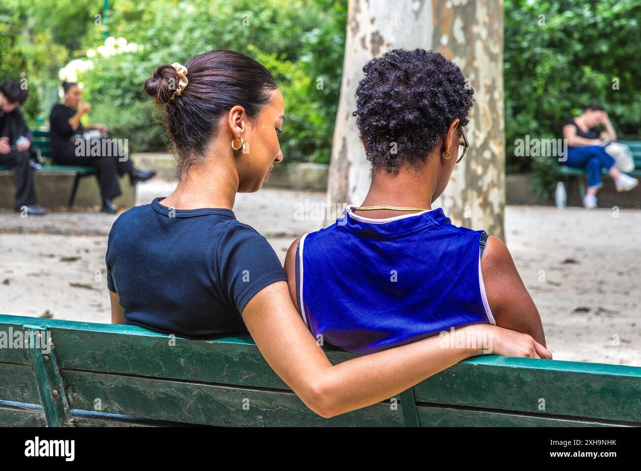 Zwei junge Frauen - möglicherweise Geliebte - saßen auf der Parkbank im Square Boucicaut, Paris 75007, Frankreich. Stockfoto