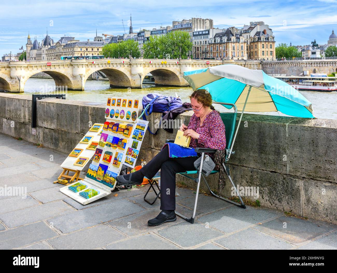 Die Künstlerin arbeitet und verkauft ihre Kunstwerke am Quai du Louvre, Paris 75001, Frankreich. Stockfoto