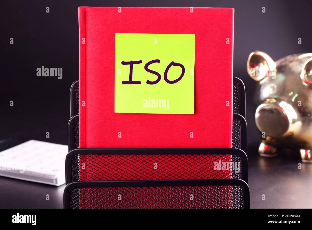 Die Abkürzung ISO ist auf dem Aufkleber im roten Geschäftsbuch vermerkt Stockfoto