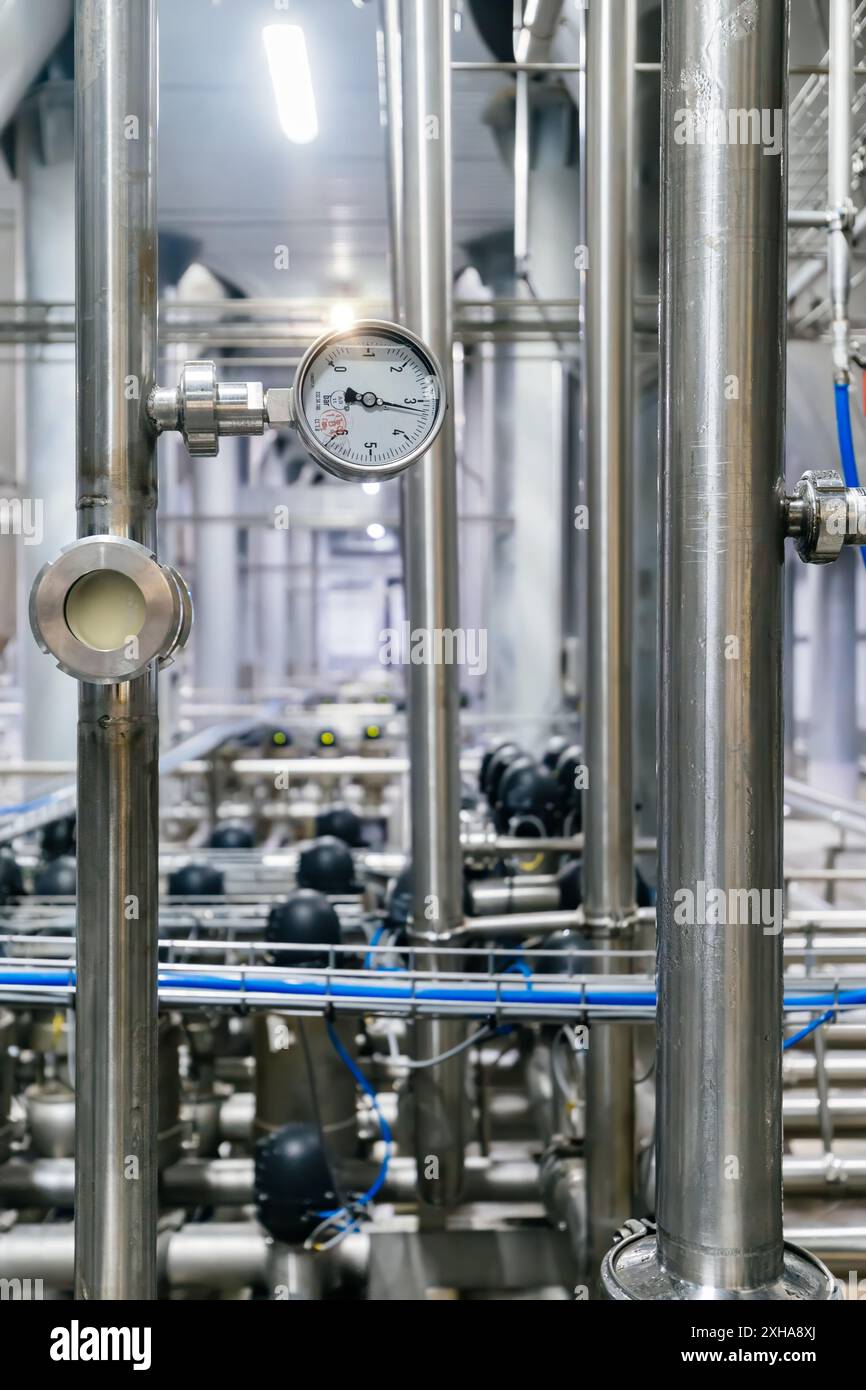 Große industrielle Edelstahlrohre und Manometer in einer modernen Brauerei. Stockfoto