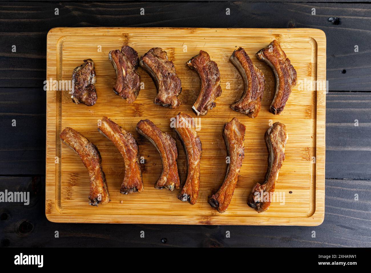 Schweinerippchen, die in einer gusseisernen Pfanne gebraten wurden: Goldbraune Baby-Back-Rippchen ohne Sauce, die nach dem Rösten in der Pfanne gebraten wurden Stockfoto