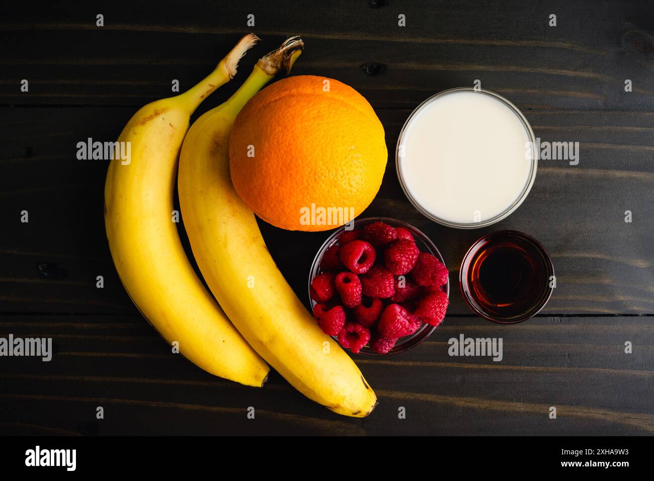 Zutaten der Raspberry Orange Smoothie Bowl: Frisches Obst mit Mandelmilch und Ahornsirup für eine vegane, glatte Schüssel zum Frühstück Stockfoto