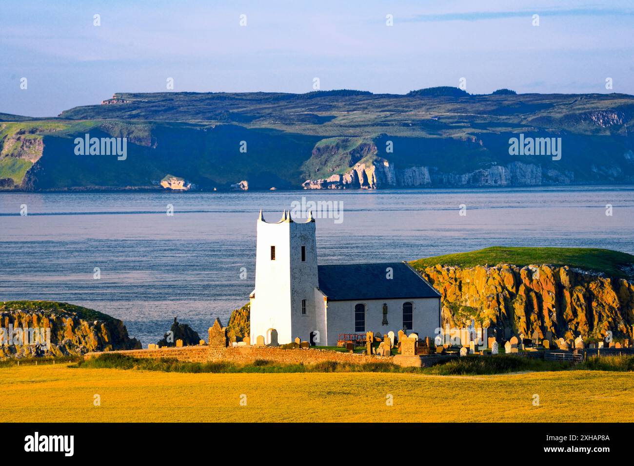 Ballintoy Pfarrkirche in Ballintoy Harbour in der Nähe von Bushmills an County Antrim Coast Road. Rathlin Insel hinter. Nordirland Stockfoto