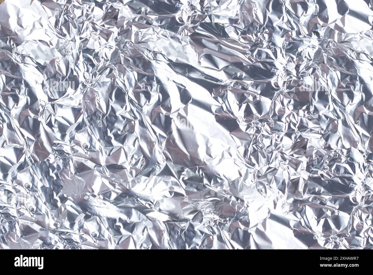 Ein Blick auf die Falten der Aluminiumfolie als Hintergrund. Stockfoto