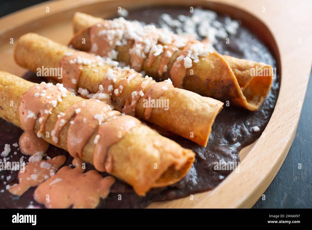 Eine Nahaufnahme von drei Taquitos auf einem Teller. Stockfoto