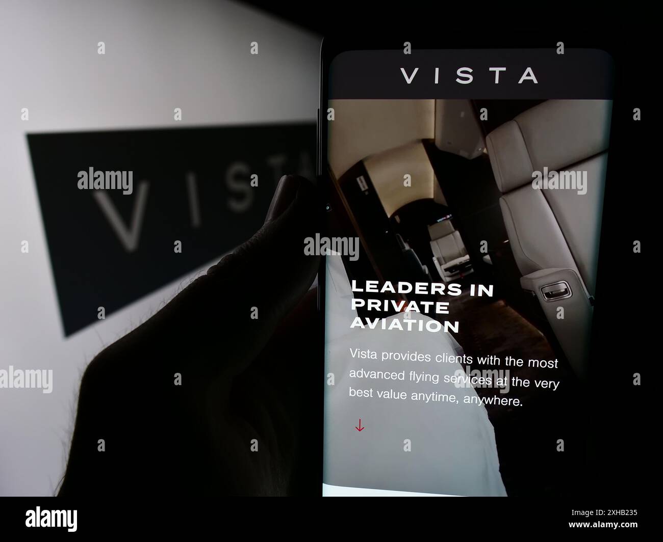 Person, die ein Mobiltelefon hält, mit der Webseite des Emirati Aviation Company Vista Global Holding Limited vor dem Logo. Konzentrieren Sie sich auf die Mitte des Telefondisplays. Stockfoto