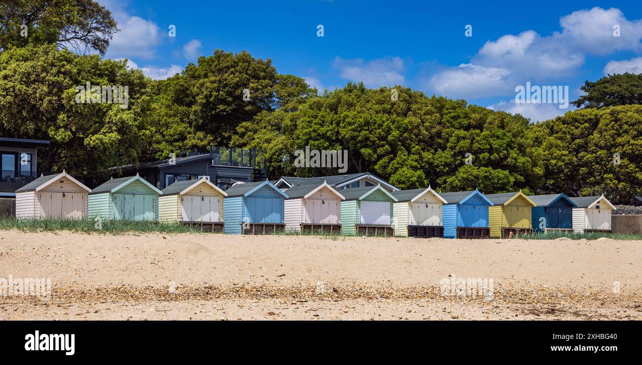 Eine Reihe farbenfroher Strandhütten in Mudeford in Dorset, England, Großbritannien Stockfoto