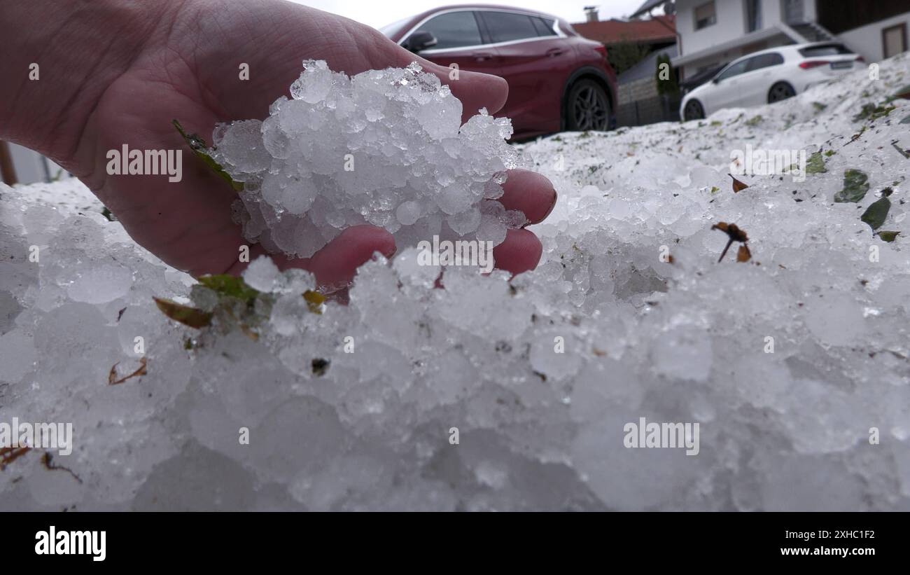 Ein extremes Hagelunwetter samt Orkan wütete am Freitagabend in der Ortschaft Brunnthal und der Gemeinde Höhenkirchen-Siegertsbrunn. Gegen 21:30 Uhr fegte eine gewaltige Unwetterfront über die Region hinweg. Im Gepäck enorme Hagelmassen. In den Ortschaften fiel zu viel Hagel, dass die Gullys verstopften. Vom Sommer in den Winter in kurzer Zeit: Amateuraufnahmen zeigen, wie große Eisschollen durch Höhenkirchen-Siegertsbrunn schwimmen. Tiefster Winterfäuste im Sommer auch knapp 20 Stunden nach dem schlimmen Unwetter liegt der Hagel noch meterhoch. Große Hagelberge findet man an Grundstücken. Di Stockfoto