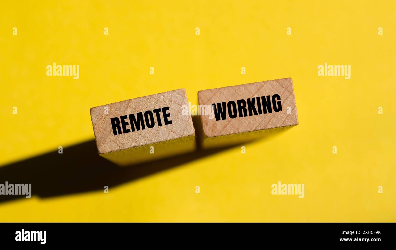 Meldung über Fernbetrieb auf Holzblöcken mit gelbem Hintergrund. Konzeptionelles Symbol für Remote Working. Kopierbereich. Stockfoto