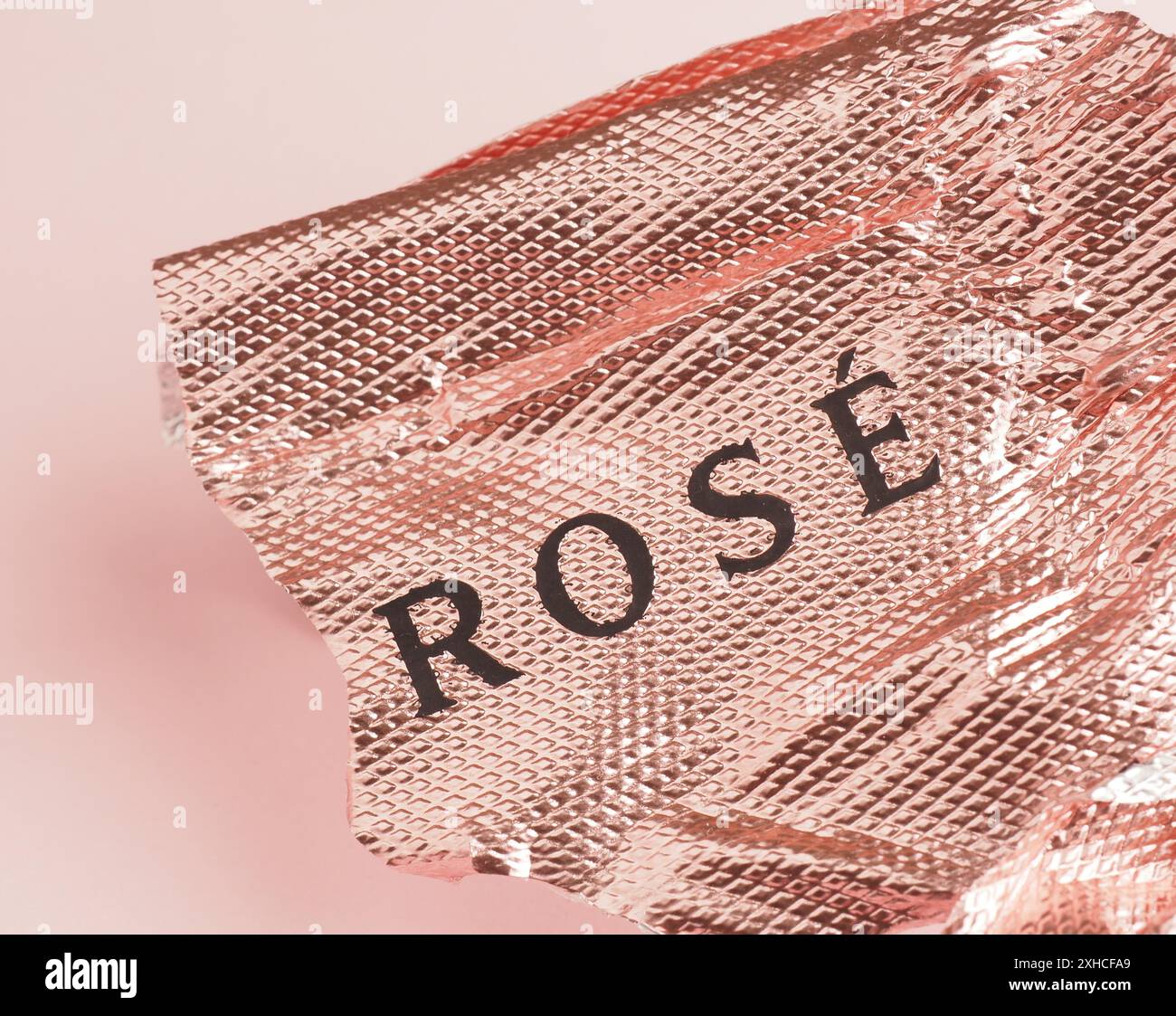 Aluminiumfolie mit den Worten Rose auf rosafarbenem Hintergrund mit Platz für Text Stockfoto