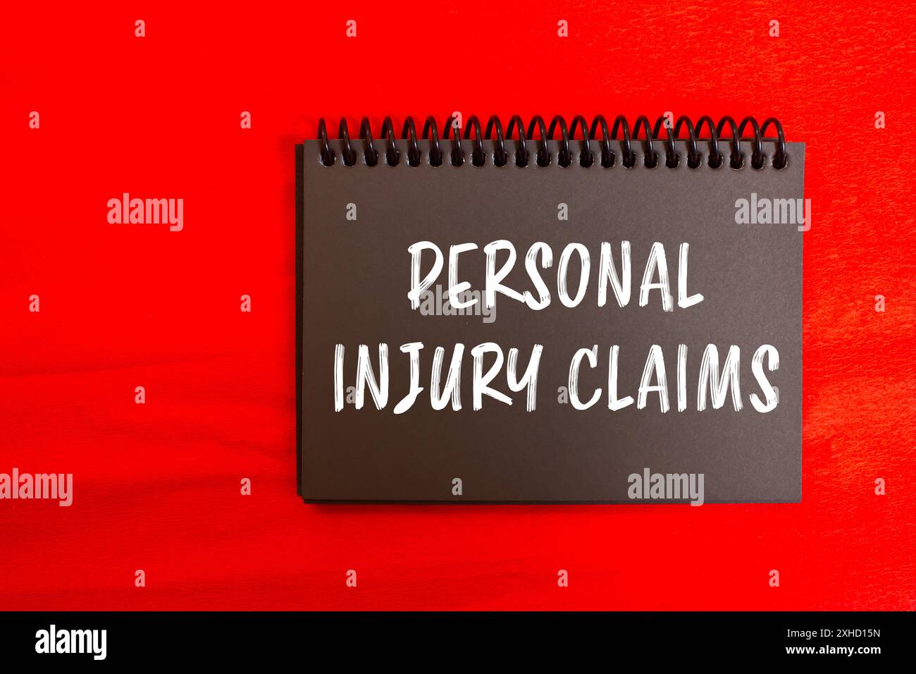 Meldung über Schadenersatzansprüche bei Personenschäden auf schwarzer Notizbuchseite mit rotem Hintergrund. Symbol für konzeptionelle Personenschäden. Kopierbereich. Stockfoto