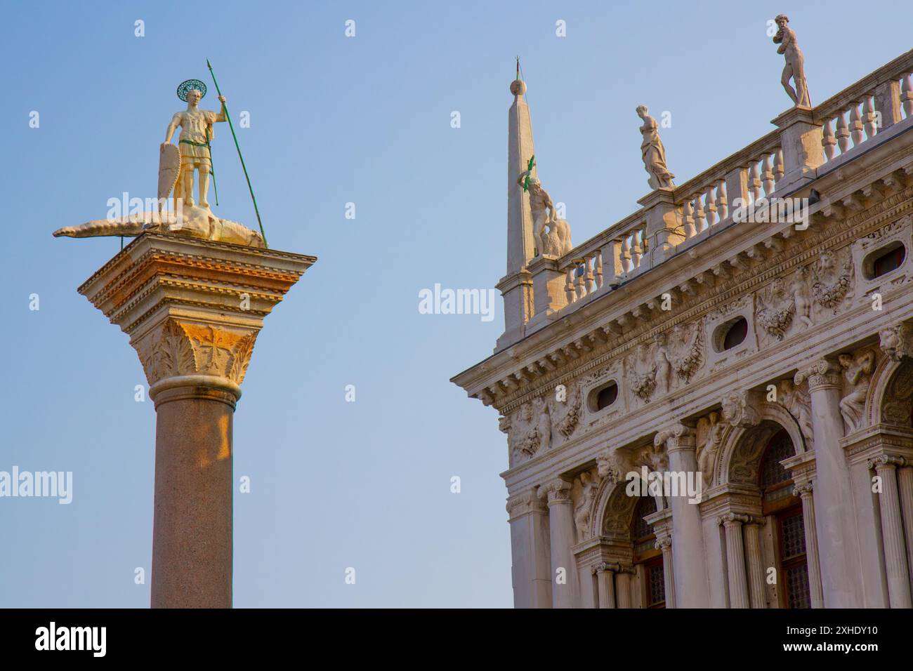 Nahaufnahme einer Spitze einer Säule von St. Theodore (Schutzpatron von Venedig) und der Markusbibliothek. Markusplatz. Venedig, Italien. Stockfoto