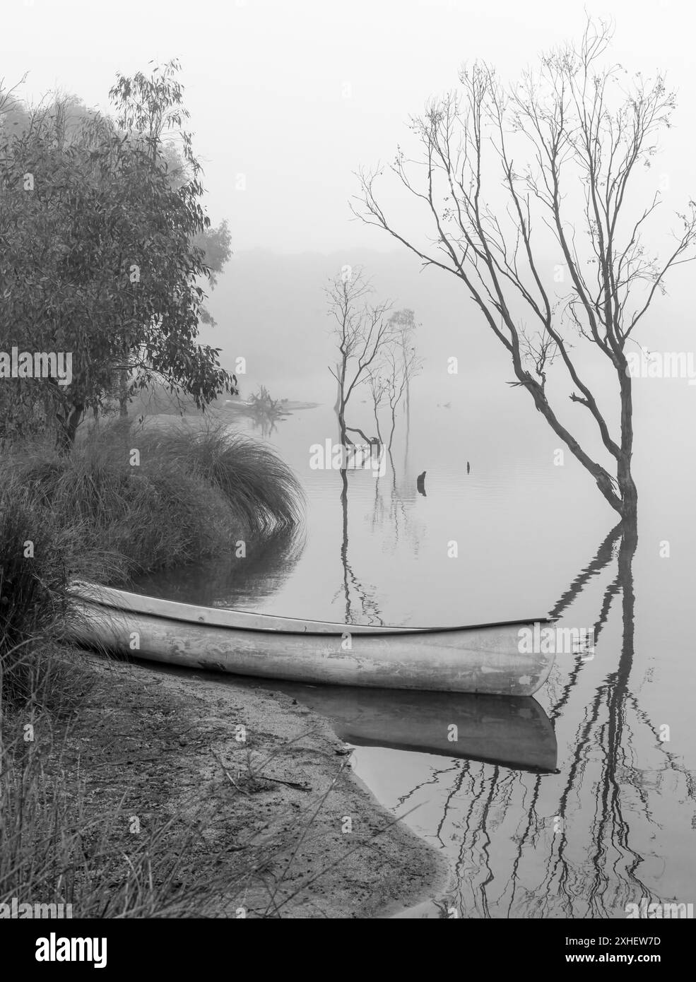 Der neblige Start in den Tag am Granite Belt, Queensland, Australien, mit einer schwarz-weißen Szene, einschließlich Kajak und Reflexionen. Stockfoto