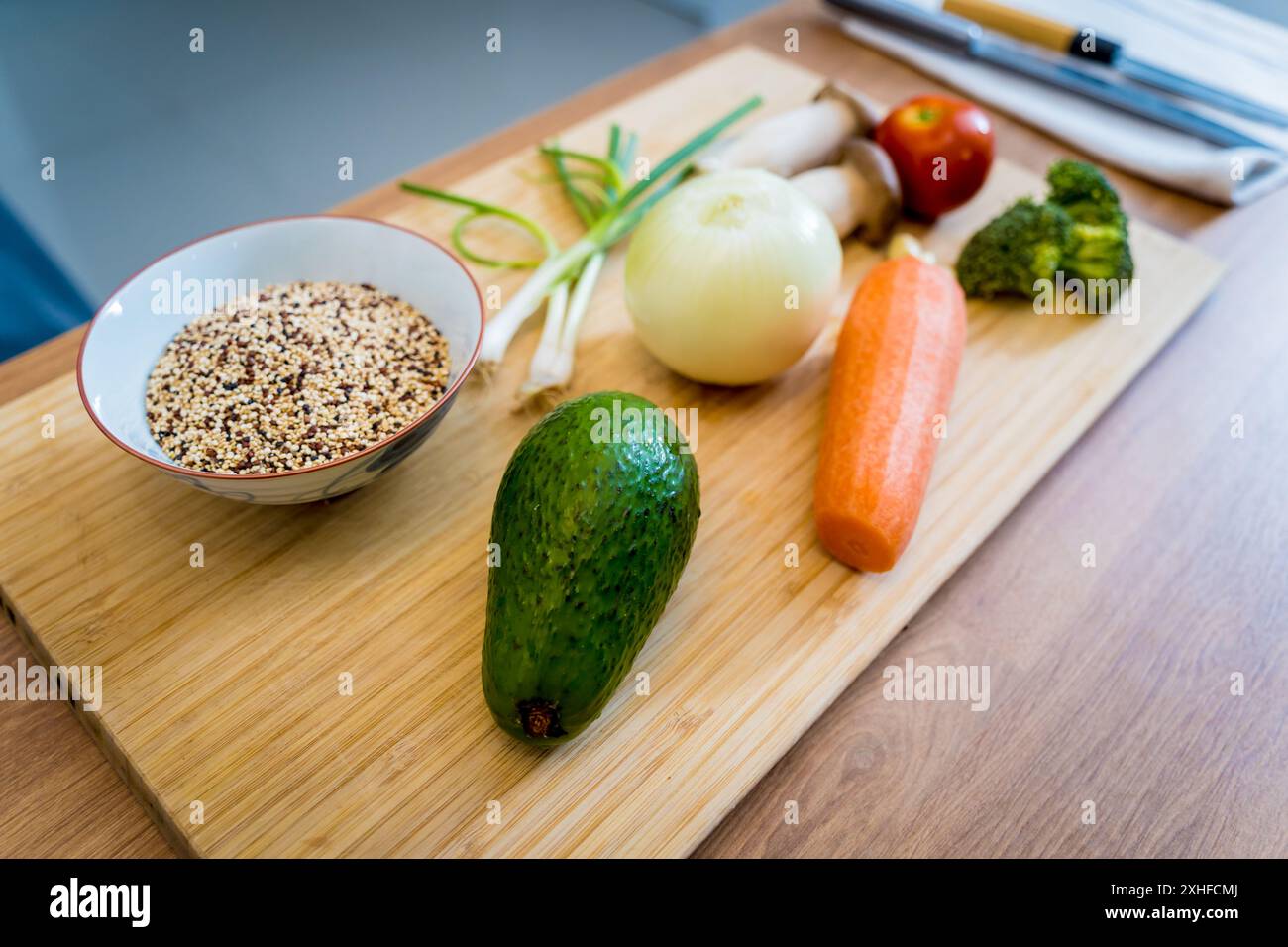 Schneidebrett mit Zutaten für die Zubereitung gesunder Quinoa-Schüssel mit Avocado Stockfoto