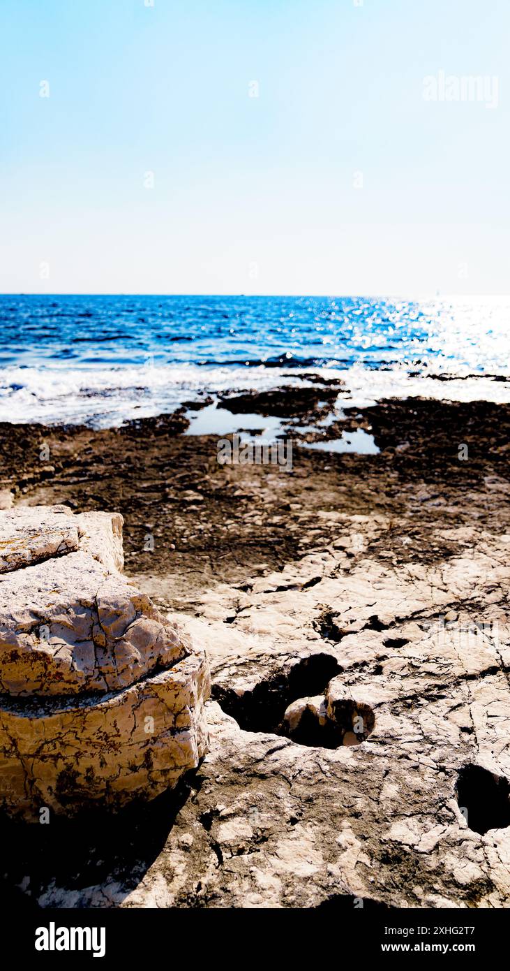 Herzförmiges Loch an der felsigen Küste mit Meer im Hintergrund Stockfoto