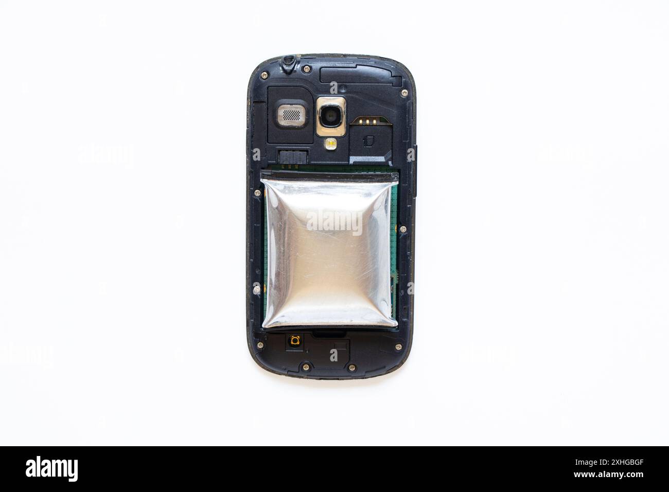 Ein Telefonakku ist durch Überhitzung geschwollen und ein zerlegtes Telefon liegt auf einem weißen Hintergrund, der Telefonakku ist aufgeblasen, Telefonreparatur Stockfoto