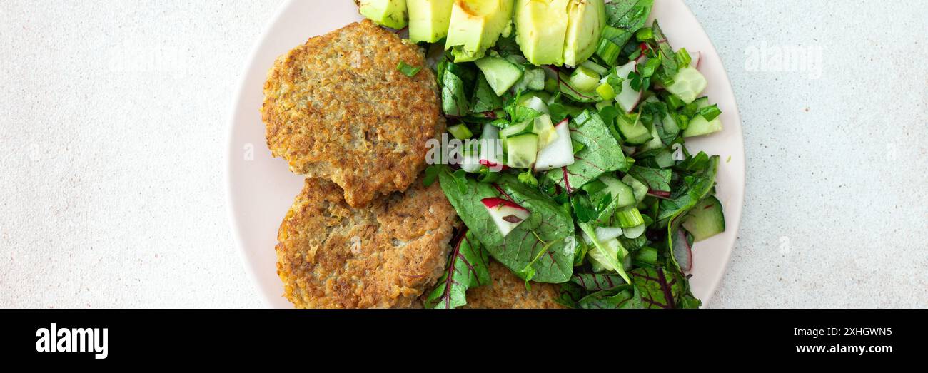Quinoa Schnitzel und gemischter Salat mit Avocado und Radieschen, Kiwi und Wasser mit Zitrone, köstliches herzhaftes Frühstück, veganes Lunch Teller Banner Stockfoto