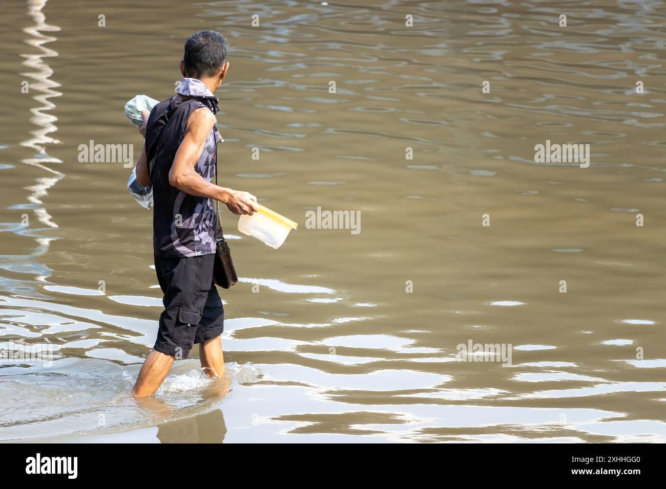 Ein Mann watet durch eine überflutete Straße, Bangkok, Thailand Stockfoto