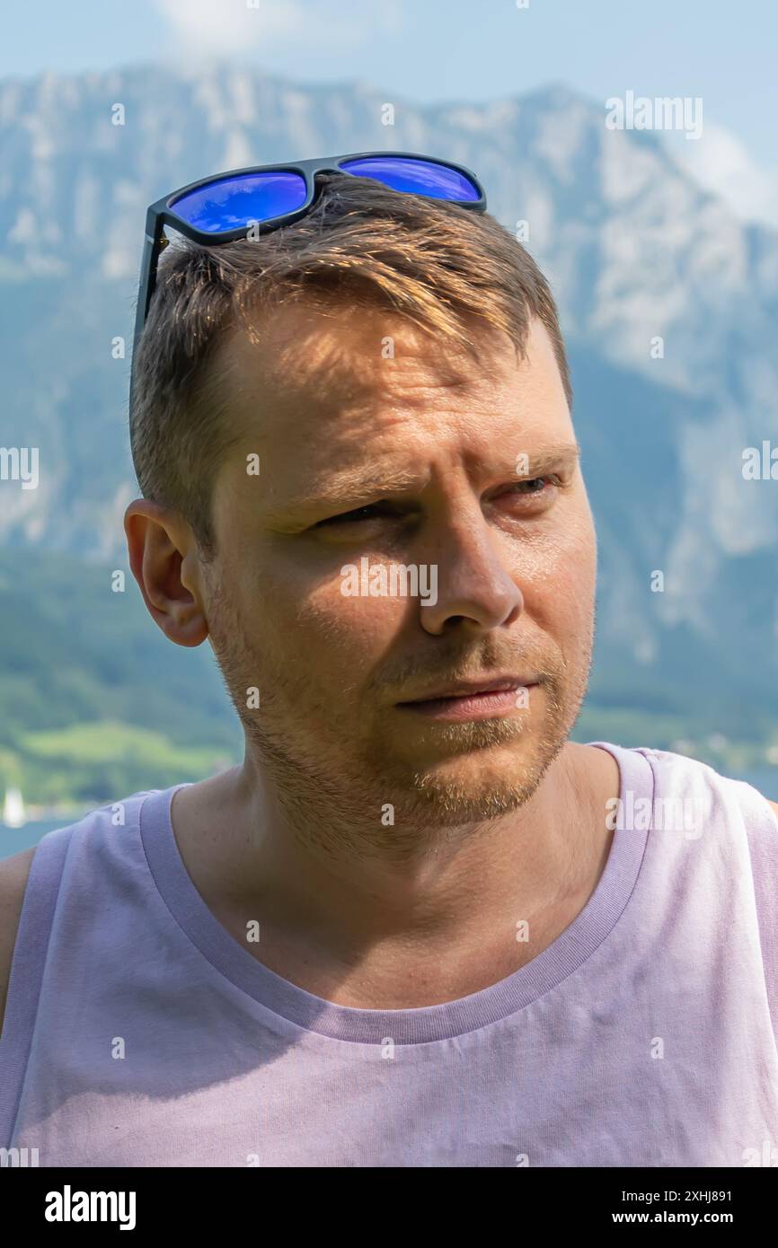 Mann mit Sonnenbrille, der in die Berglandschaft blickt Stockfoto