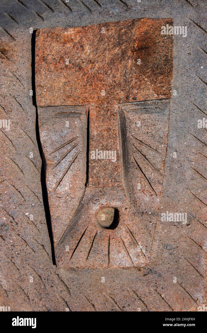 Steinschnitzereien von maskierten Gesichtern auf einem Felsen im Inuit Sculpture Park bei den Four Corners in Iqaluit, Nunavut, Kanada Stockfoto